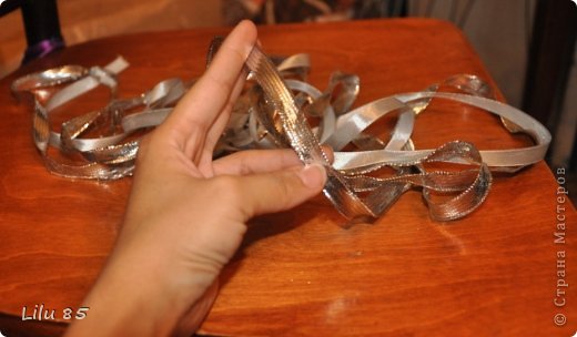 Вам понадобятся: любая пластиковая бутылка, липкая лента, ножницы, серая и розовая лента, вата, широкий ободок, толстая серая шерстяная нить, клеевой пистолет, старый серый меховой воротник или другой мех. Украсьте углы цветами или лентами разных цветов. Для начала разрежьте пластиковую бутылку на два квадрата. Скрутите квадраты, чтобы получилась плюшевая игрушка, и прикрепите ее липкой лентой. С первого раза может не получиться, поэтому покрутите и отпустите квадратики несколько раз, чтобы 